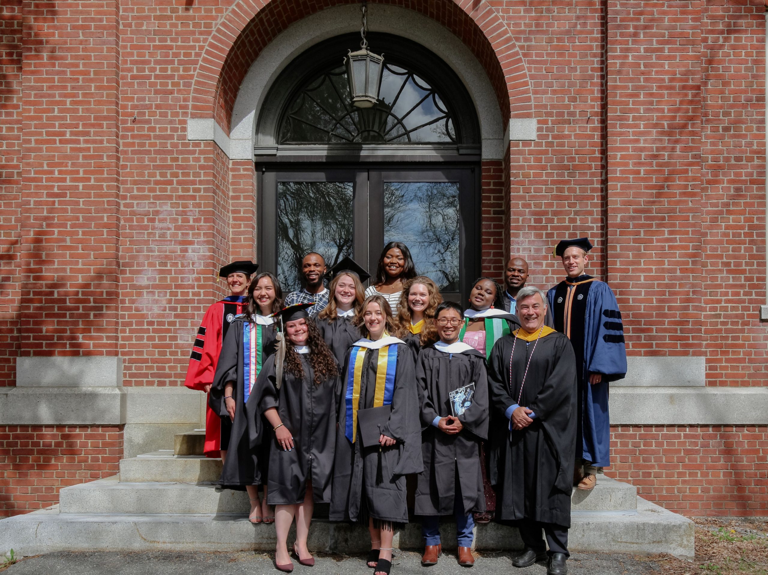 A group photo of faculty and students standing in front of a building